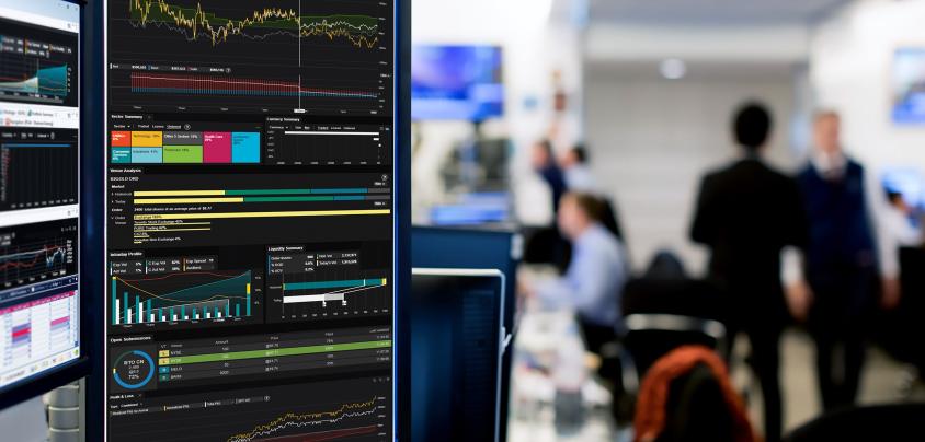 Graphs on monitor with people behind