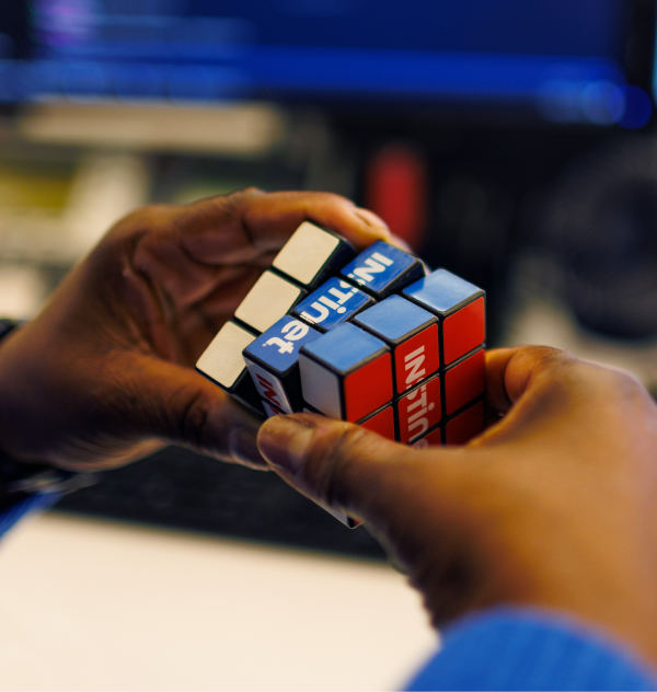 Man holding a rubix cube with Instinet printed on it